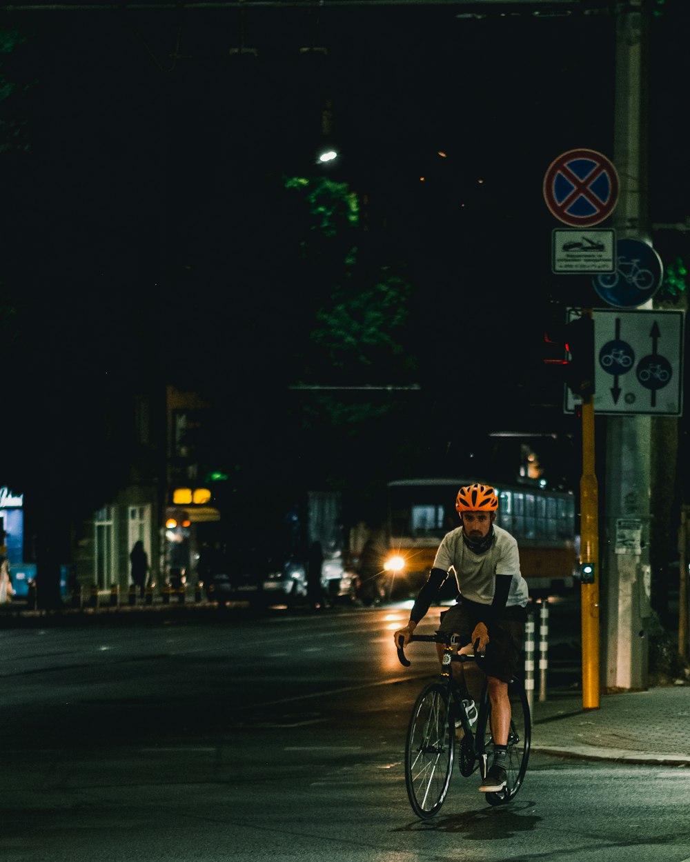 man in black jacket riding bicycle on road during night time