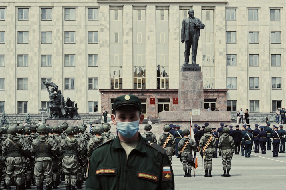 Soldados con uniforme negro parados cerca de un edificio de concreto gris durante el día