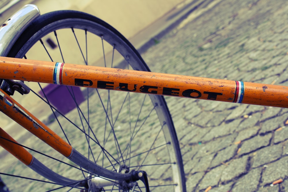 orange bicycle with black wheel