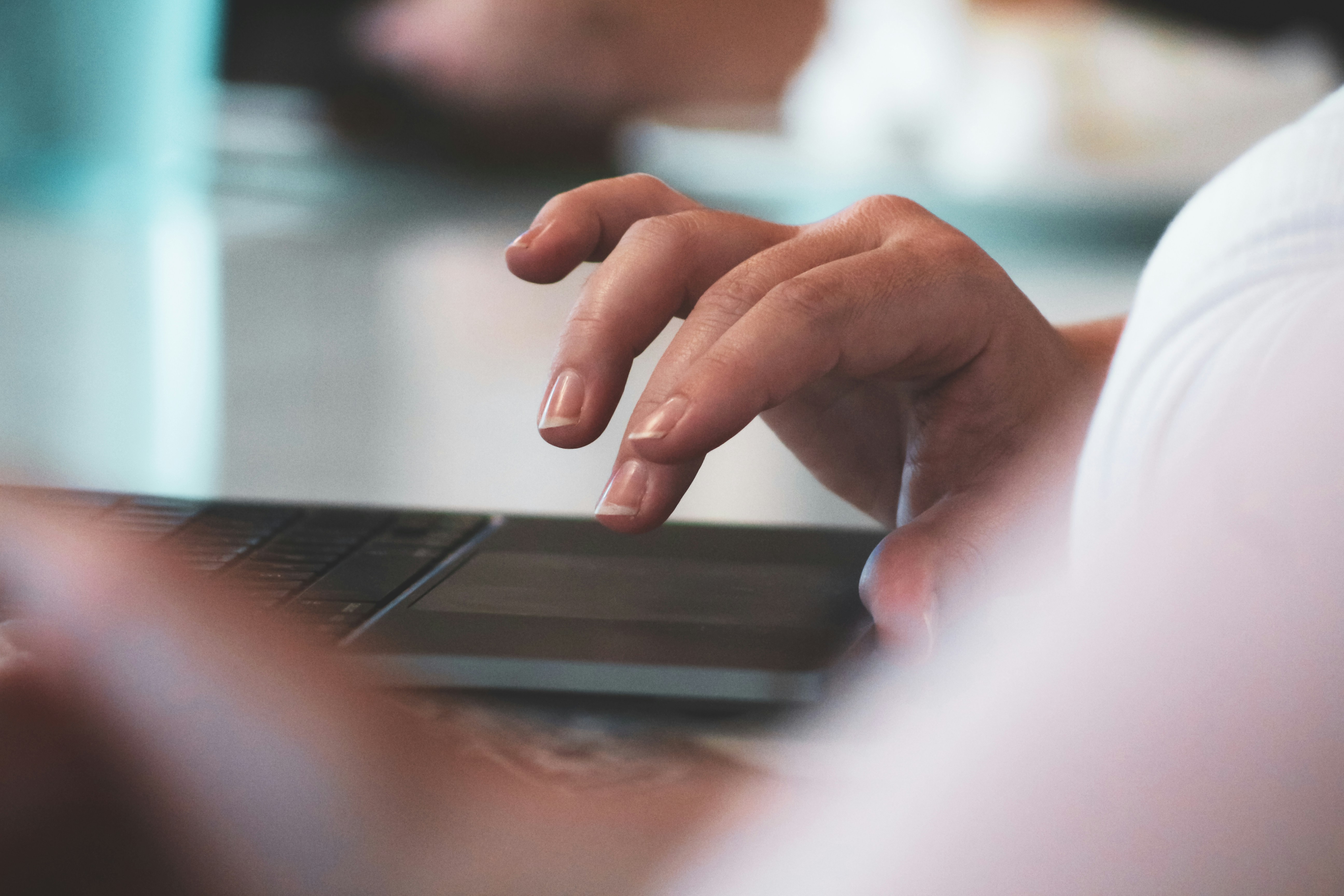 close-up view of hands gesturing on a laptop touch display