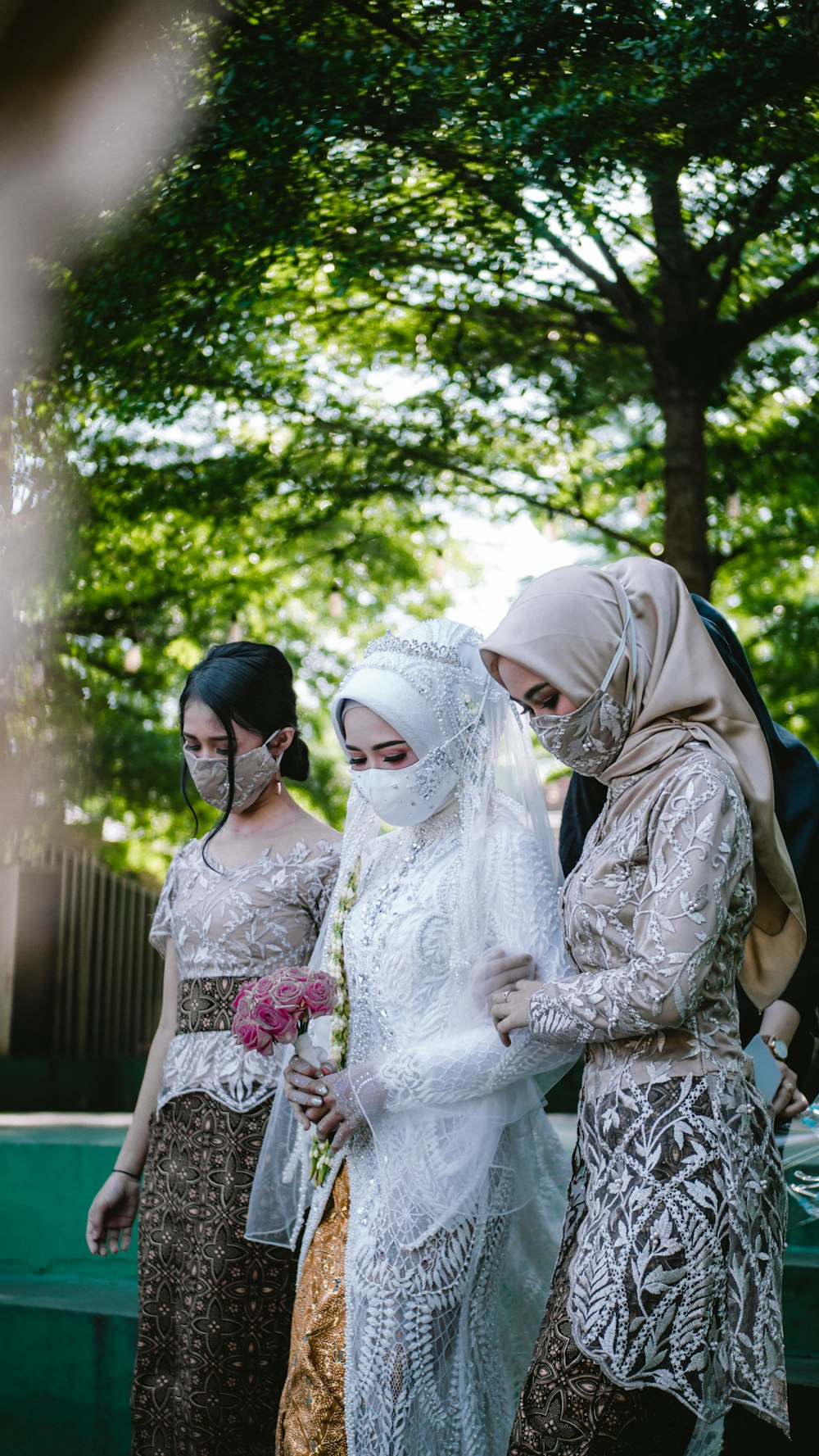 woman in white floral dress standing beside woman in brown hijab