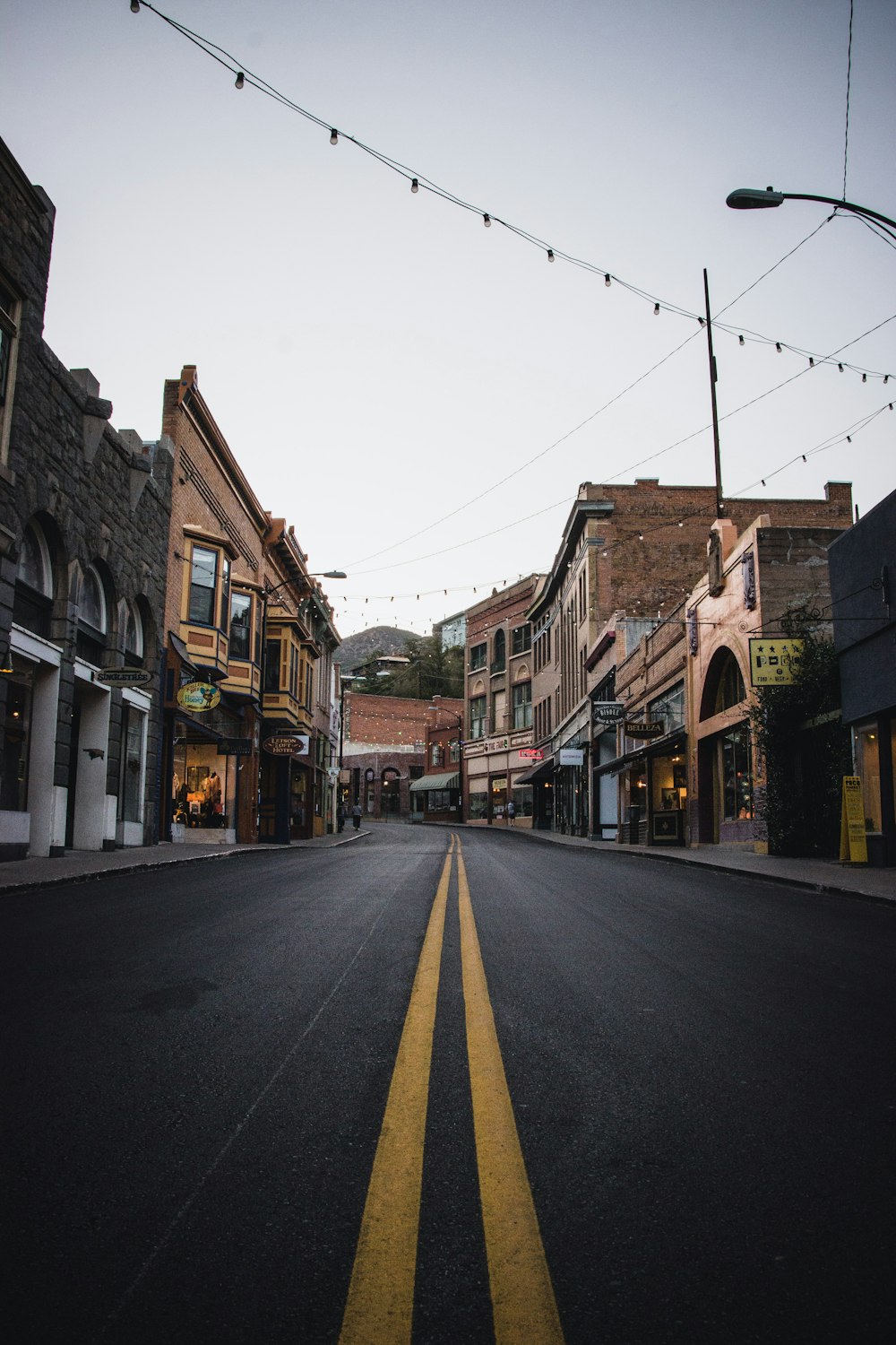 empty road between brown concrete buildings during daytime