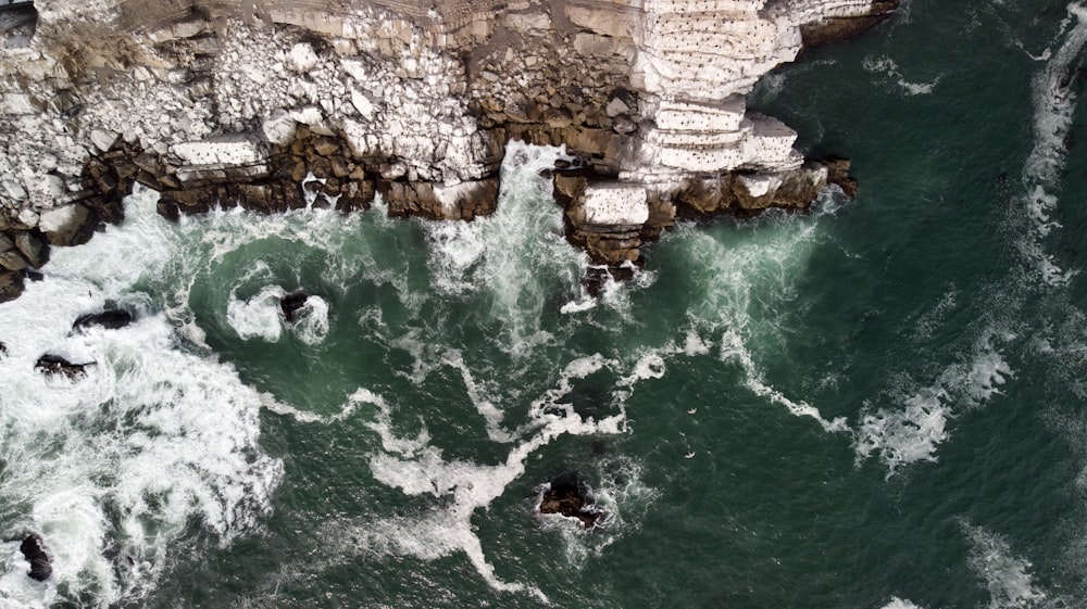 brown rock formation beside body of water during daytime