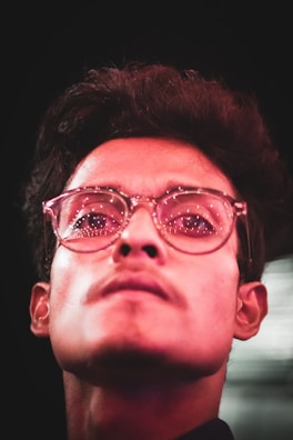 Close-up of a contributor with glasses, framed by deep violet hues.