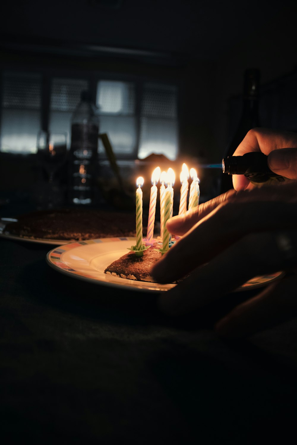 흰색 세라믹 원형 접시에 불이 켜진 촛불을 들고 있는 사람