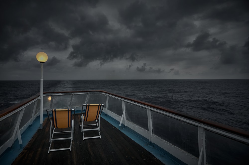 white and yellow boat on sea under gray clouds