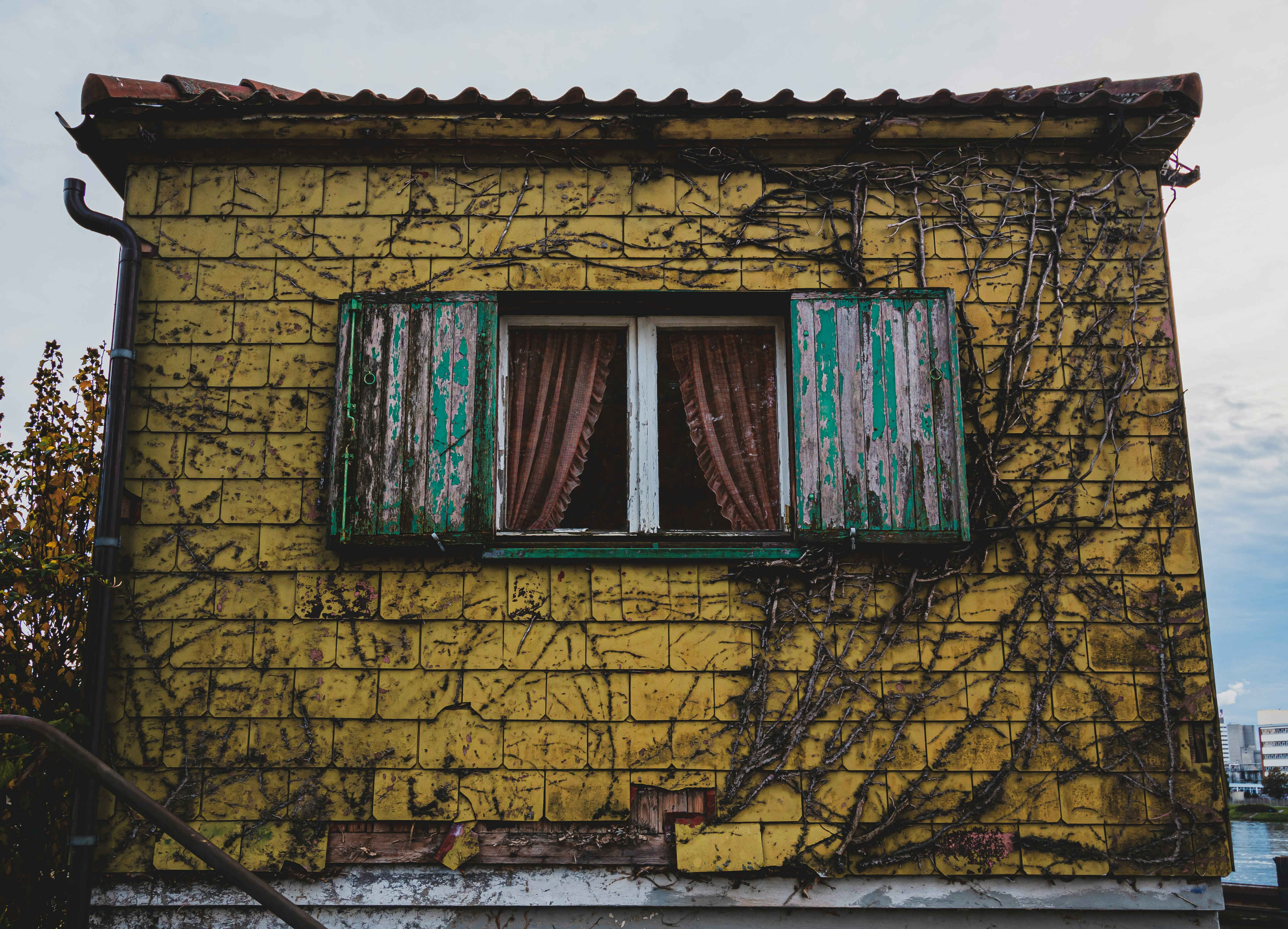 brown wooden window on yellow brick wall