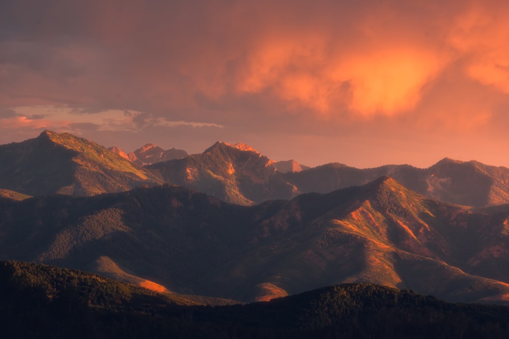 brown and black mountains under orange sky