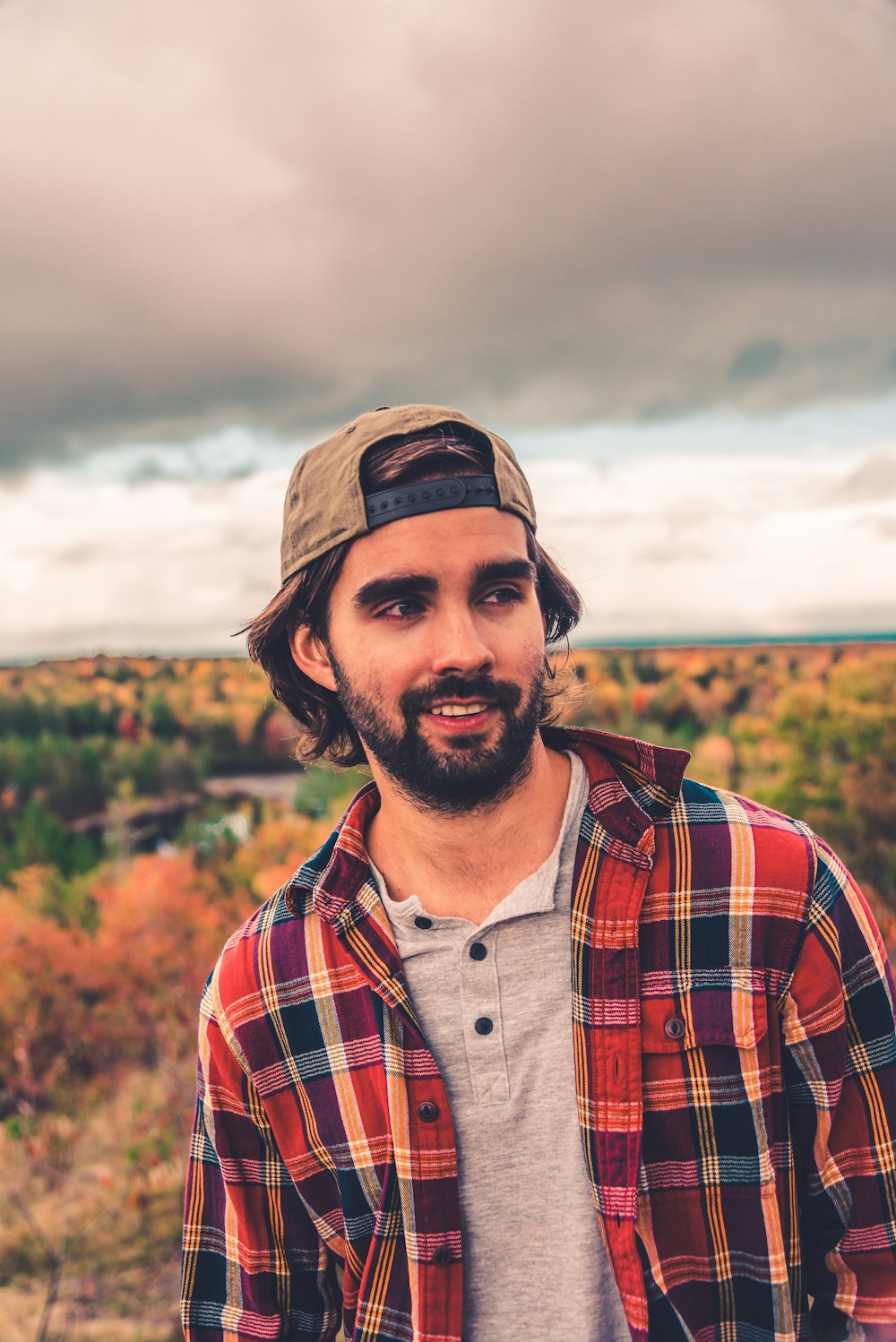 man in red white and black plaid button up shirt wearing brown hat