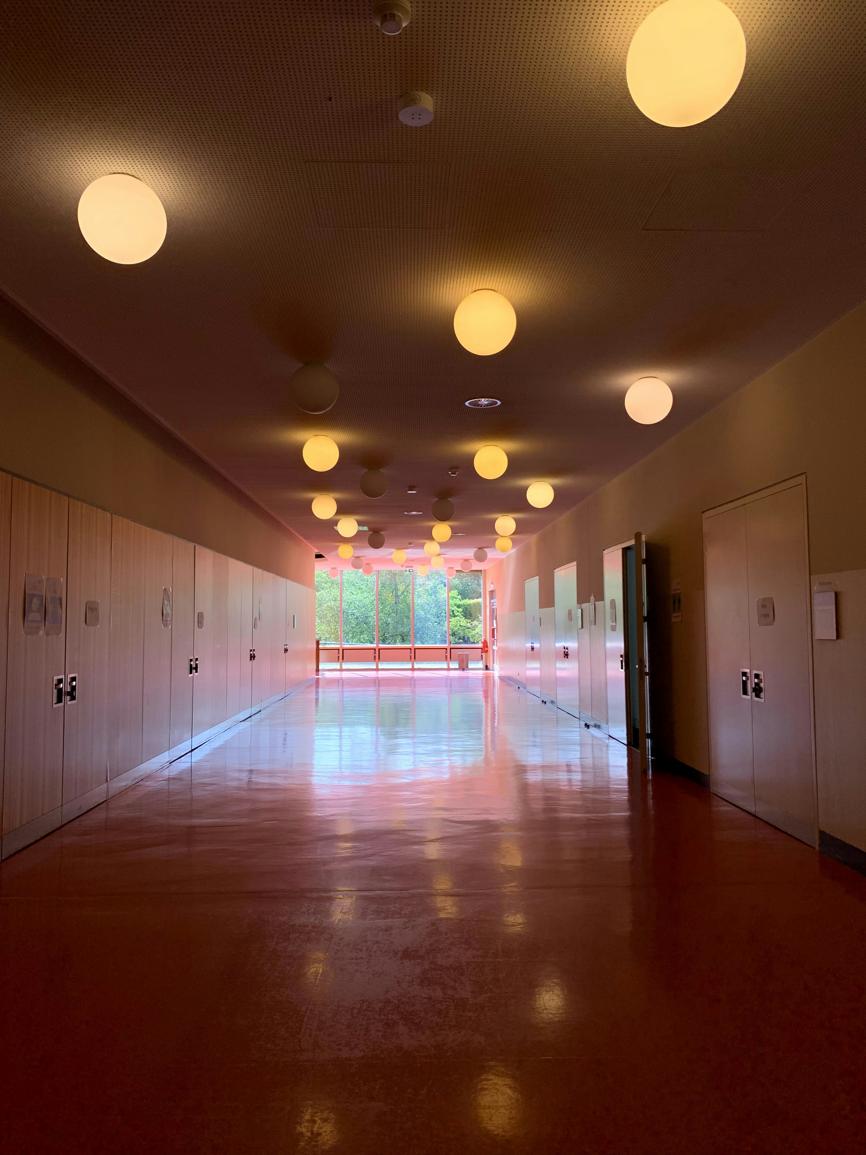 white and brown hallway with white ceiling lights
