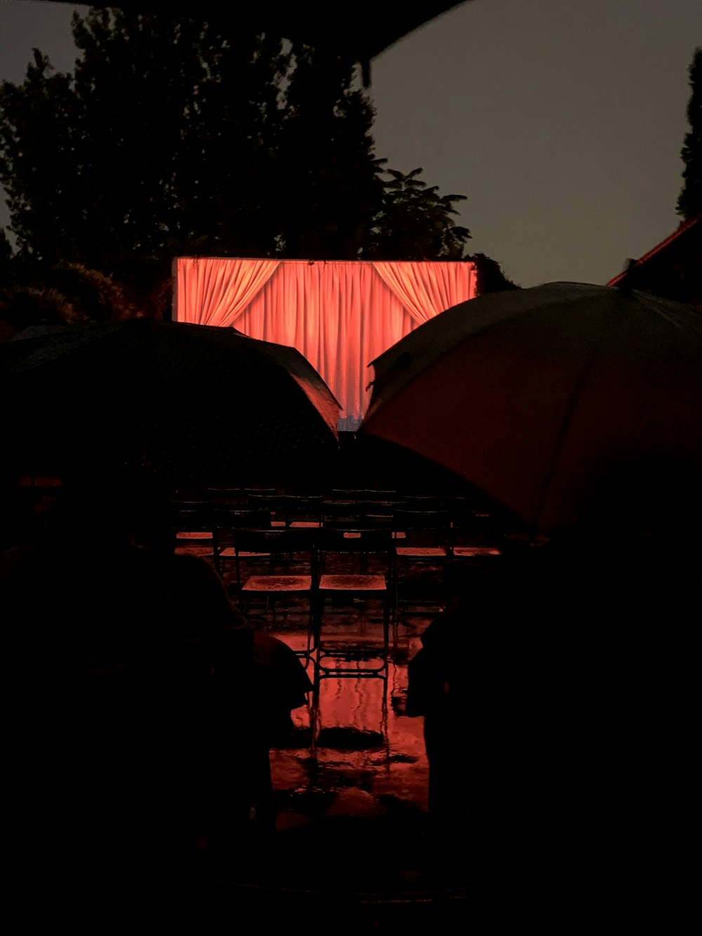 silhouette of people standing under umbrella during night time