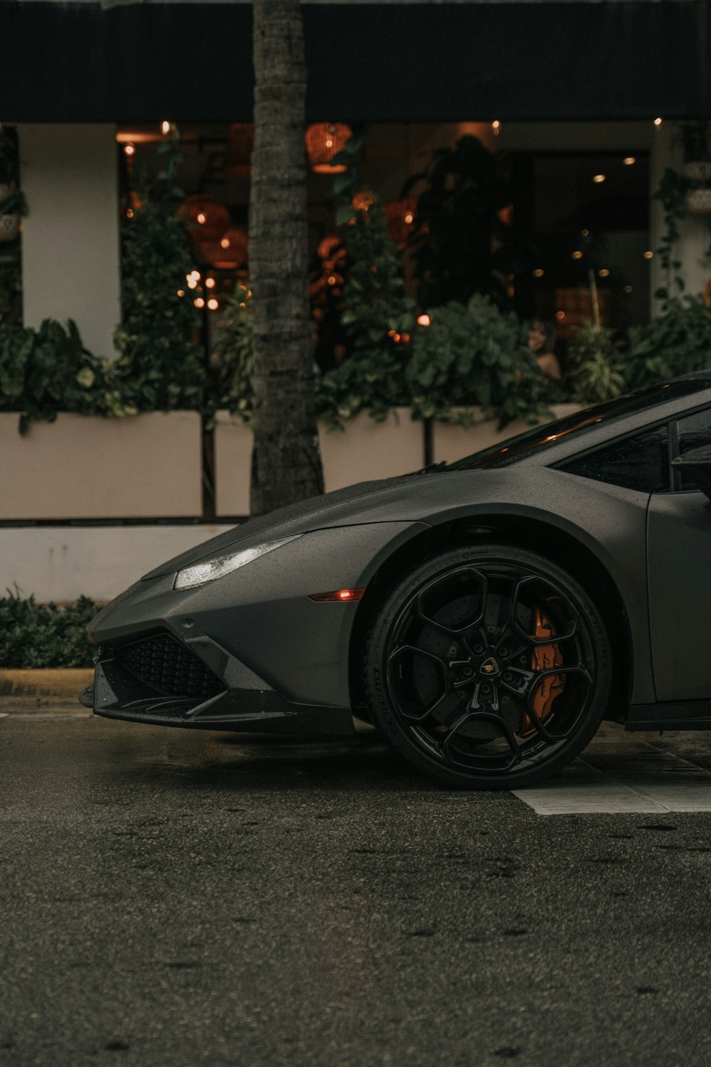 Schwarzer Lamborghini Aventador parkt tagsüber auf grauer Betonstraße