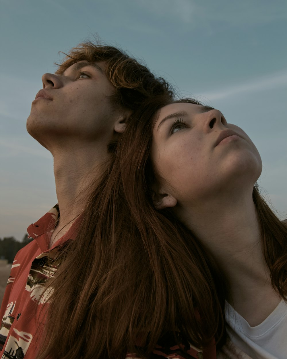 uomo e donna che si baciano sotto il cielo blu durante il giorno