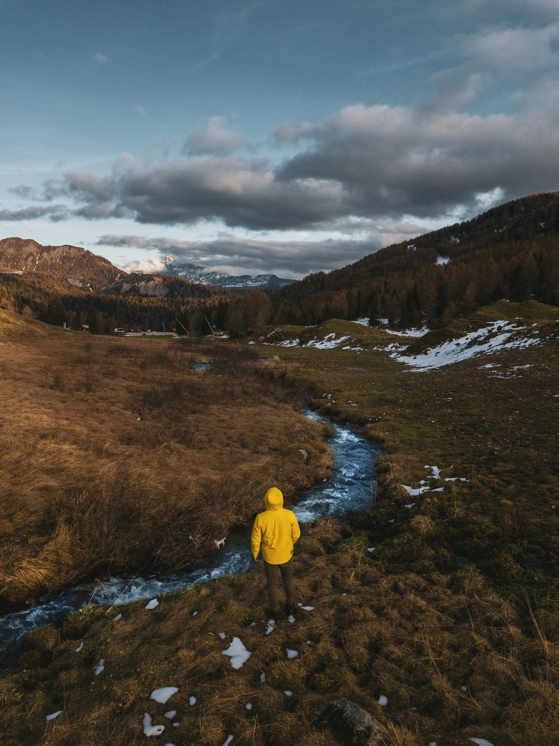 person in yellow hoodie standing on brown field during daytime