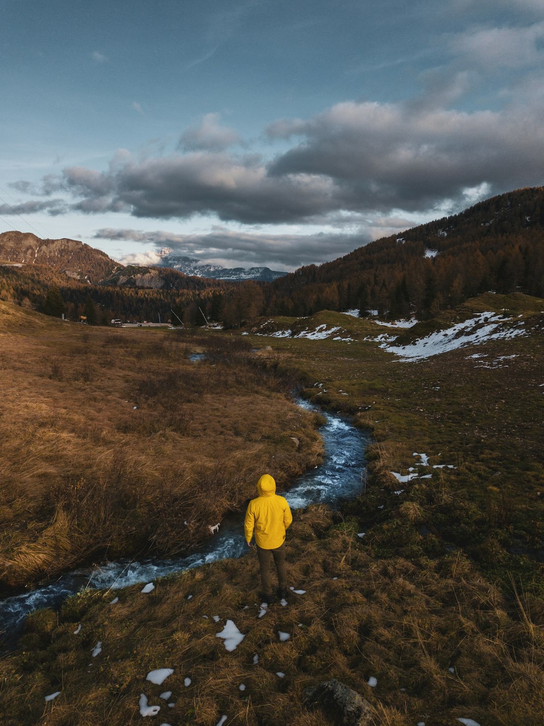 person in yellow hoodie standing on brown field during daytime