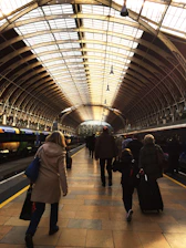 A bright, colorful train station bustling as travelers prepare to board.