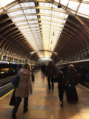 A bright, colorful train station bustling as travelers prepare to board.