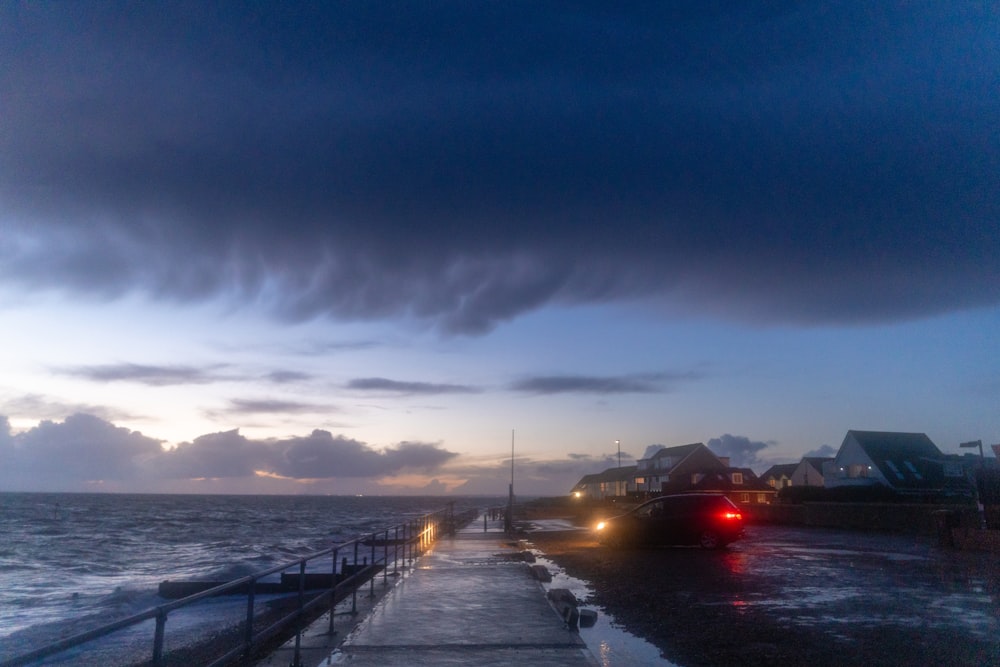 black car on road near sea during daytime