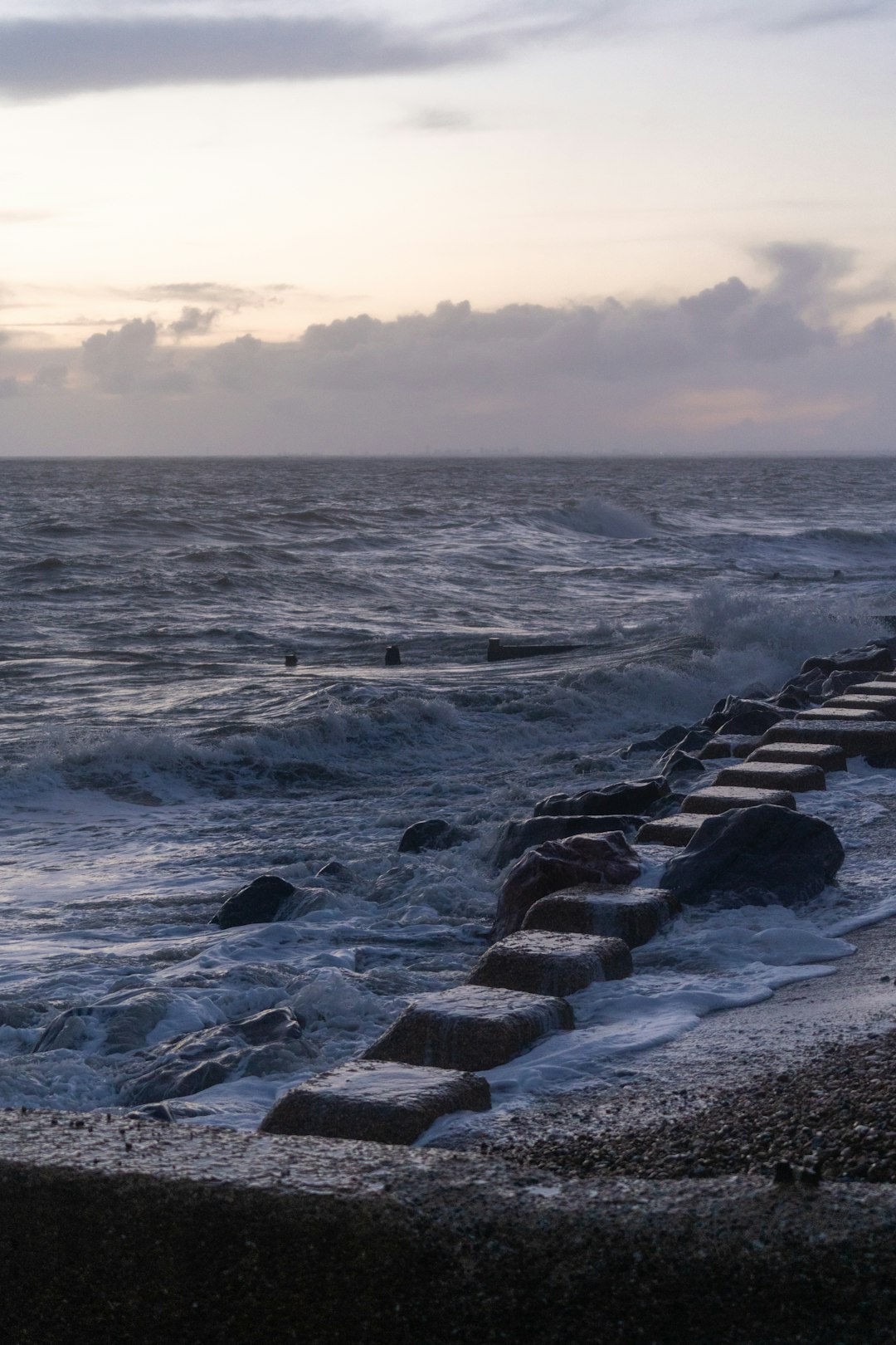 rocky shore with ocean waves during sunset