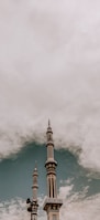white and brown concrete tower under white clouds