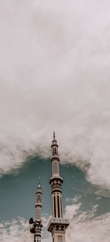 white and brown concrete tower under white clouds