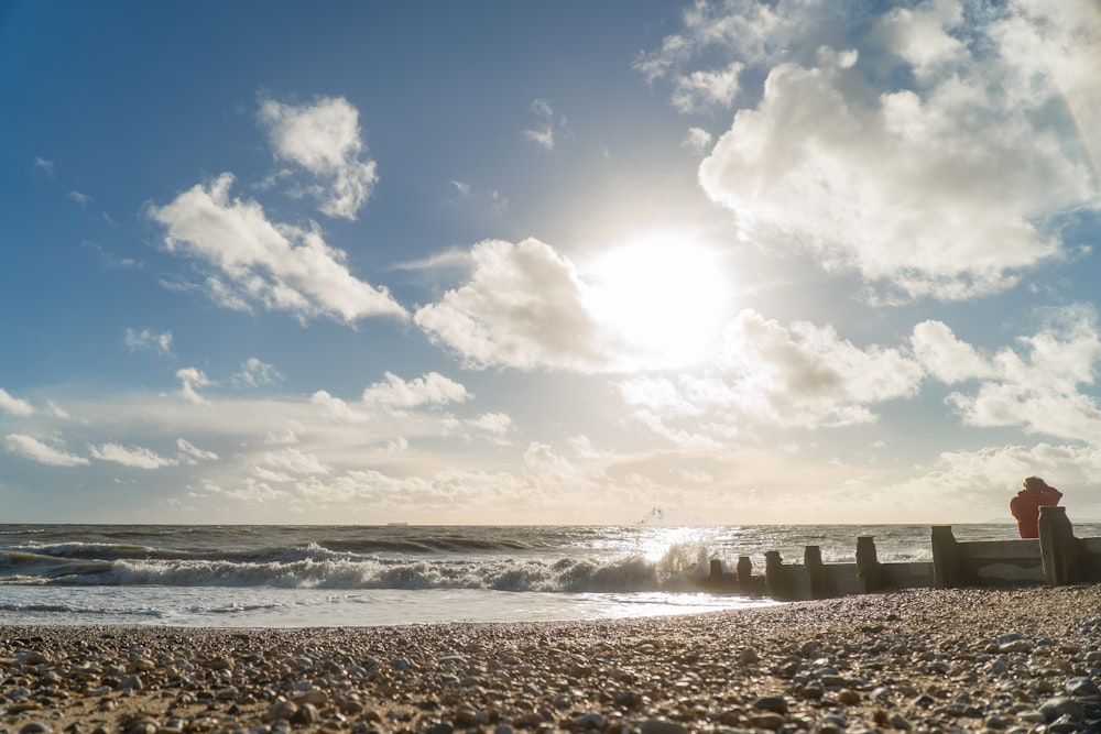 white clouds over sea waves crashing on shore during daytime