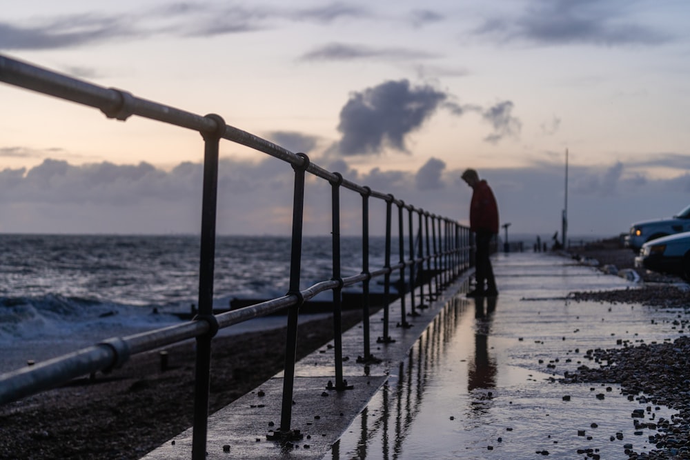 Person, die tagsüber auf einer Holzbrücke über das Meer geht