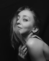 A vintage-inspired portrait of a woman bathed in soft natural light with a gentle smile.