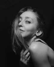 An elegant, intimate photo of a woman smiling subtly, evoking mystery.