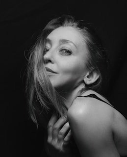 A softly lit portrait of a smiling Slavic woman in traditional attire, embodying grace and warmth.