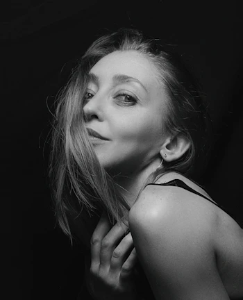 A softly lit portrait capturing gentle curves and a sultry gaze.