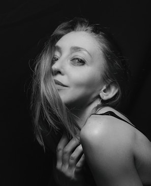 A vintage-inspired portrait of a woman bathed in soft natural light with a gentle smile.