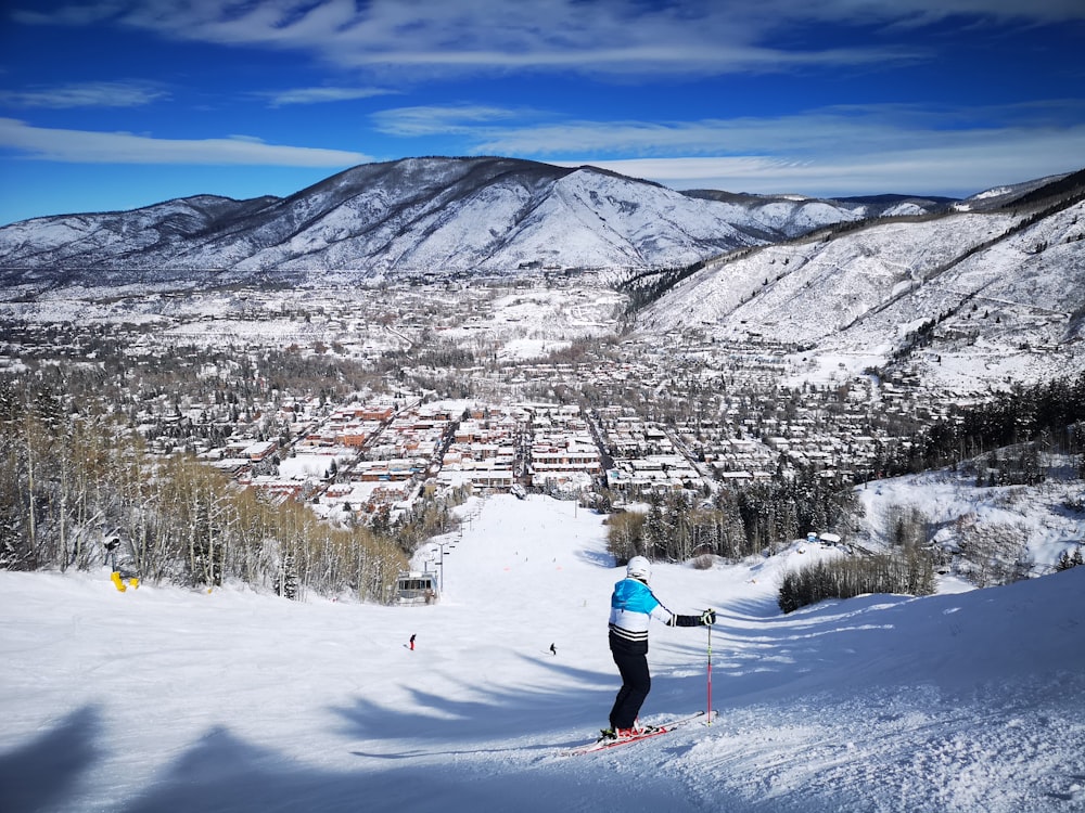 person in red jacket and blue pants riding ski blades on snow covered ground during daytime