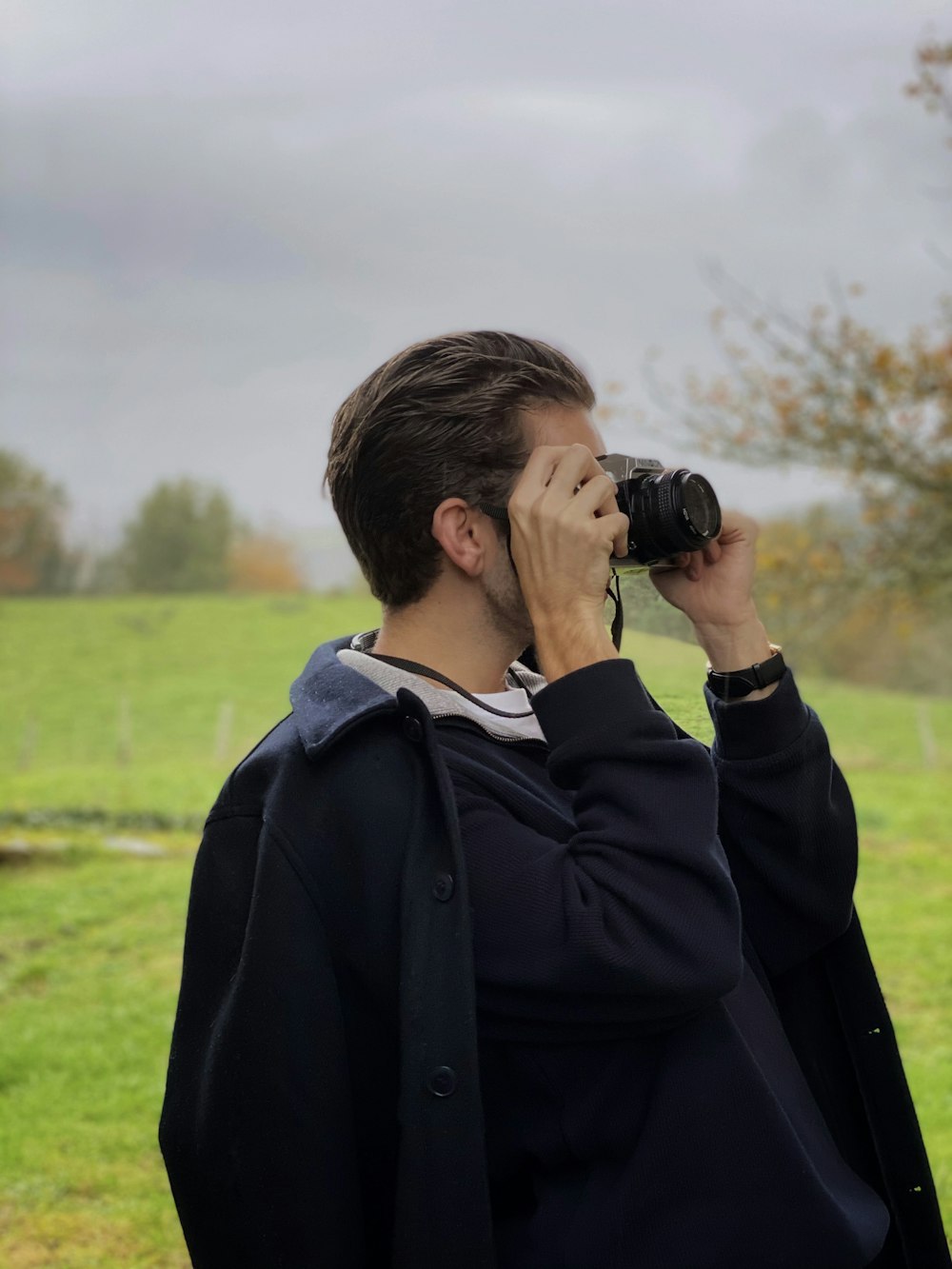 Mann in schwarzer Jacke mit Fernglas