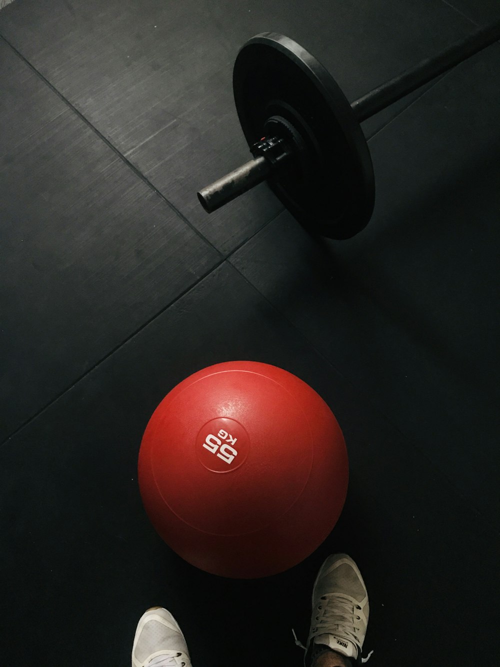 red and black dumbbell on black floor