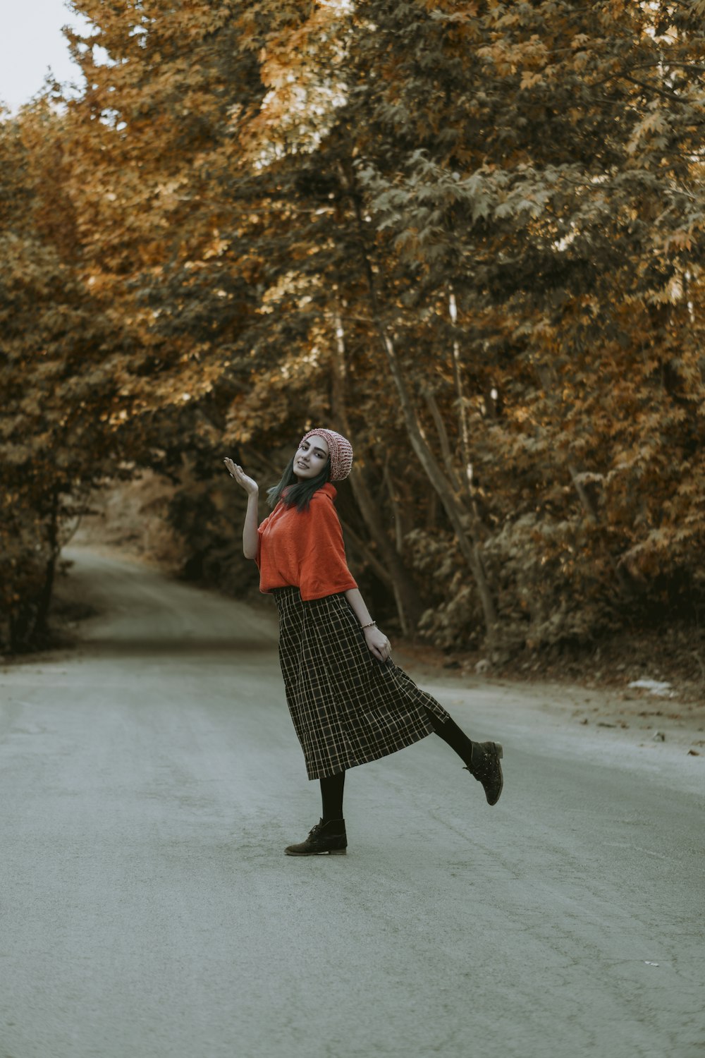 woman in red and black dress walking on road during daytime