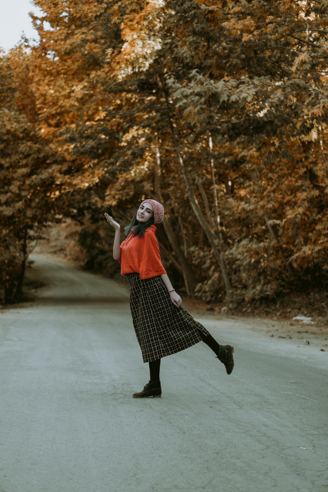 woman in red and black dress walking on road during daytime