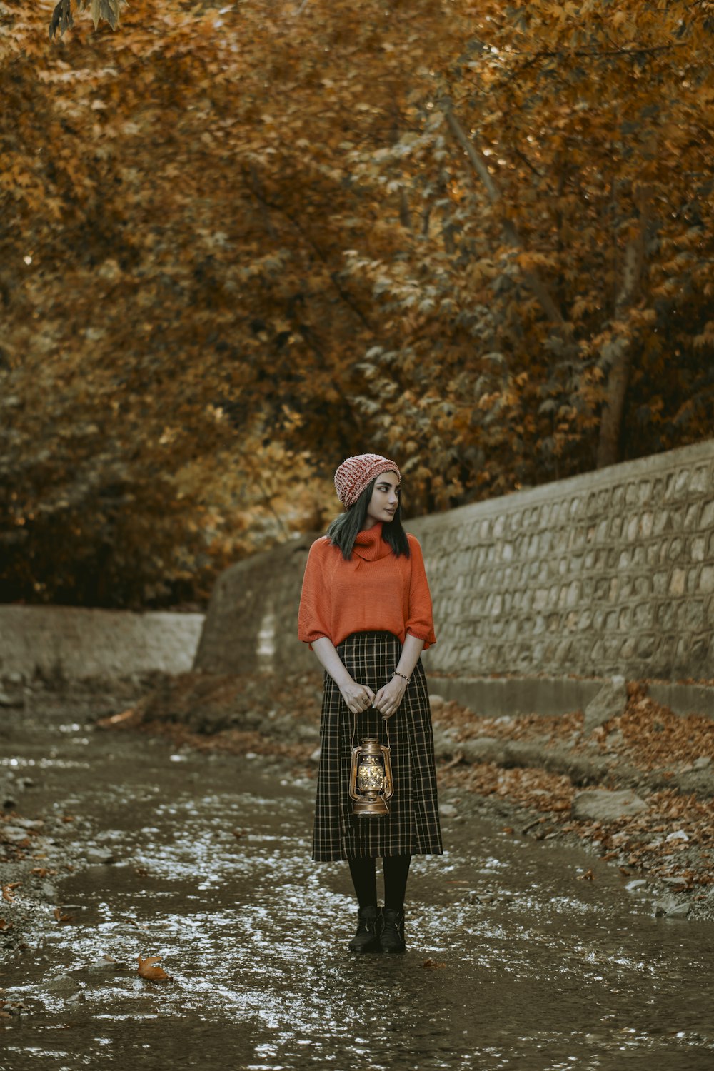 woman in red and black coat standing on river