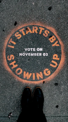 a person standing in front of a sign that says it starts by showing up
