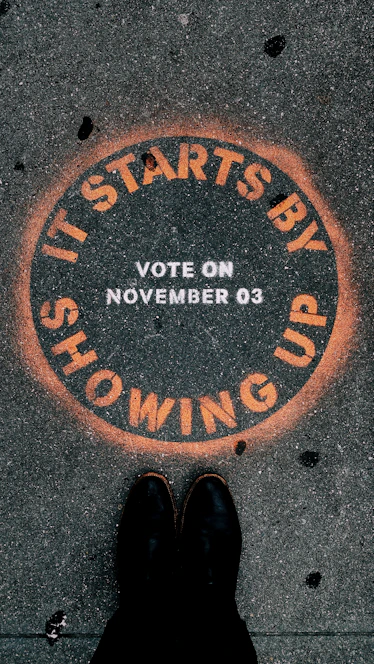 a person standing in front of a sign that says it starts by showing up