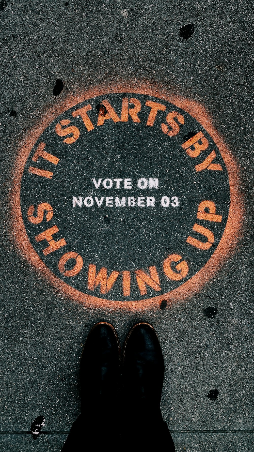 a person standing in front of a sign that says it starts by showing up