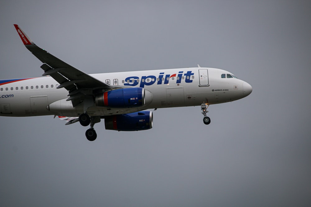 white and blue airplane under white sky during daytime