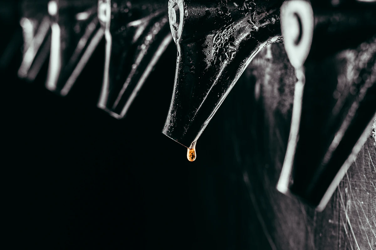 Close-up of a row of beer taps, one with a drop of beer about to fall