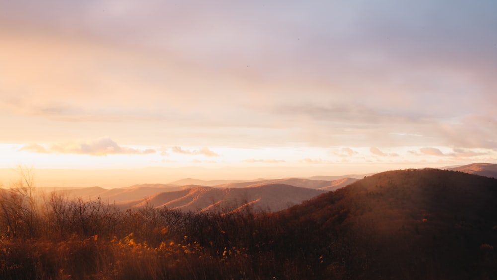 brown mountains under white clouds during daytime