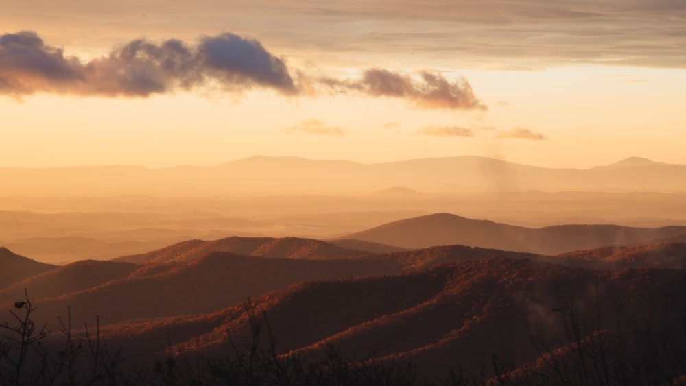 brown mountains under white clouds during daytime