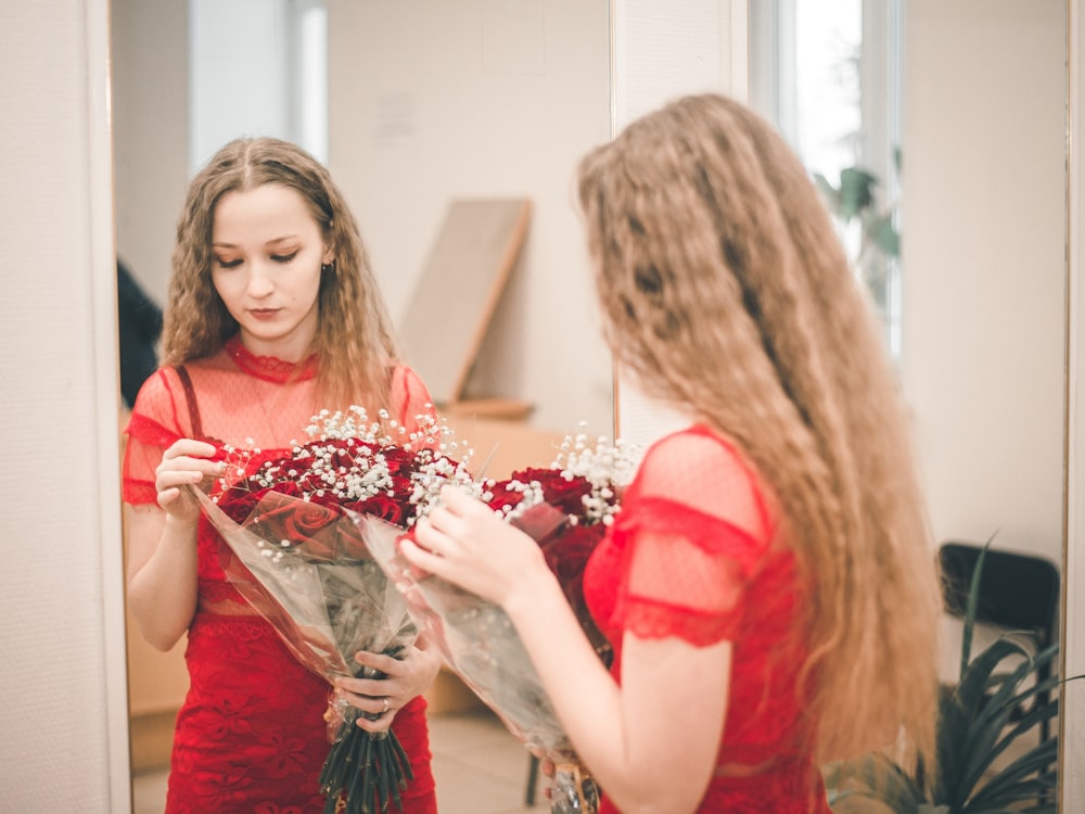 woman in red dress holding bouquet of flowers