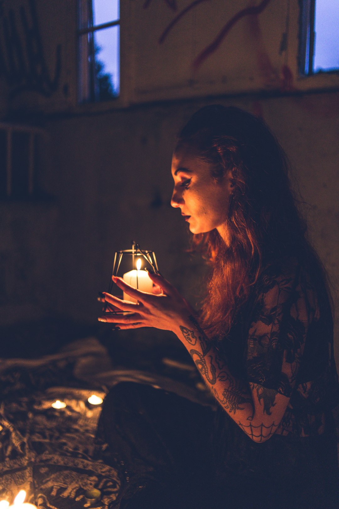 woman in black and brown floral long sleeve shirt holding lighted candle