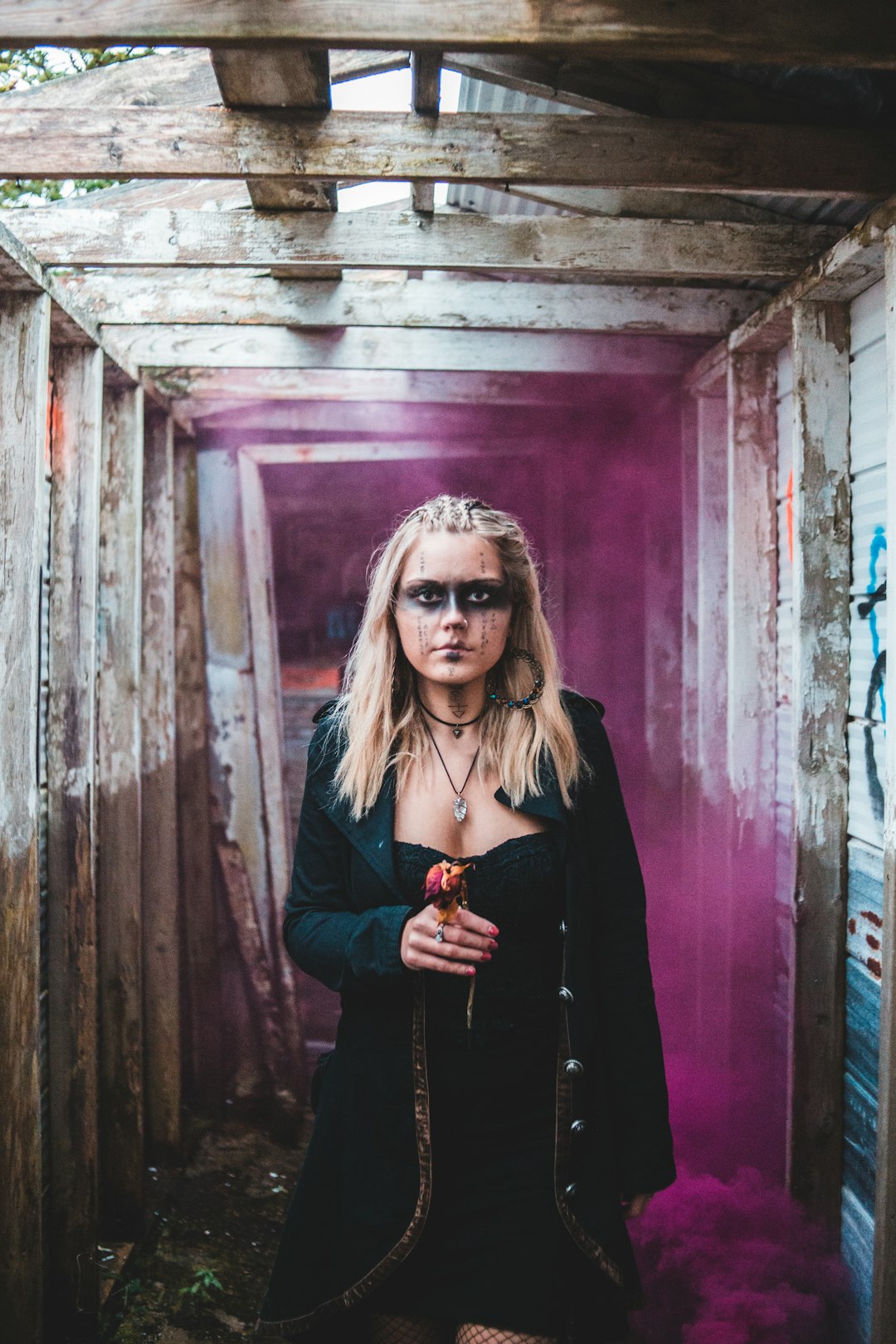 woman in black coat standing beside red wooden wall