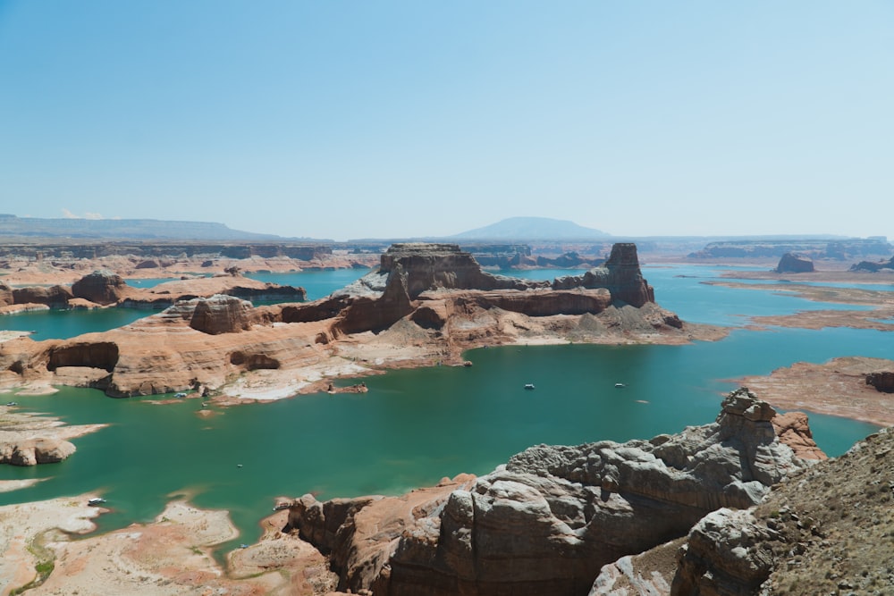 brown rocky mountain beside blue sea under blue sky during daytime