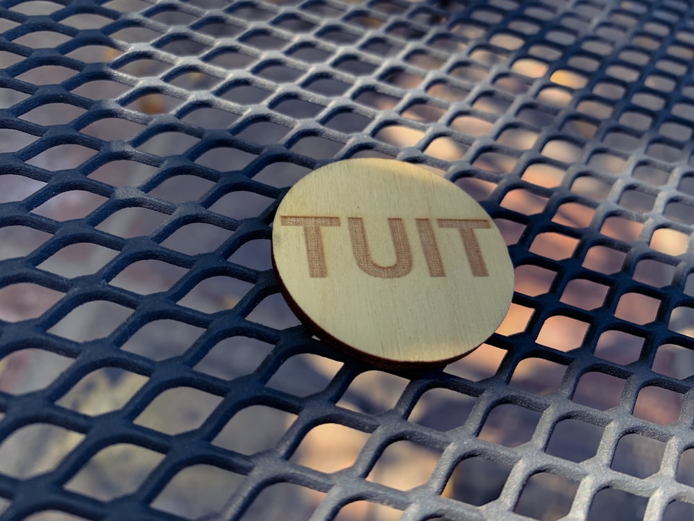 brown wooden round ornament on gray metal mesh table